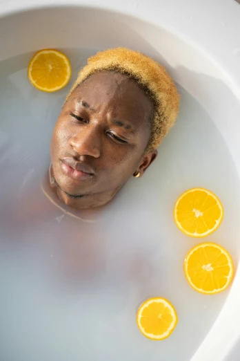 a man laying in a bath filled with orange slices, trending on pexels, renaissance, portrait of ororo munroe, healing pods, young thug, blonde man