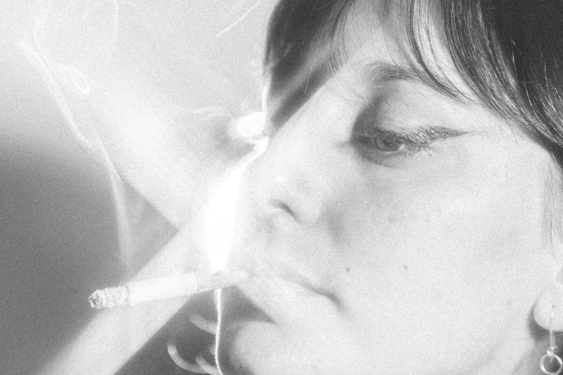 a black and white photo of a woman smoking a cigarette, flickr, surrealism, rinko kawauchi, close-up portrait film still, alice cullen, pastel'