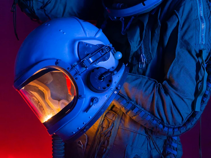 a man in a space suit holding a helmet, a portrait, by Adam Marczyński, pexels, blue and red lighting, in the cockpit of a fighter jet, thumbnail, 1960s-era