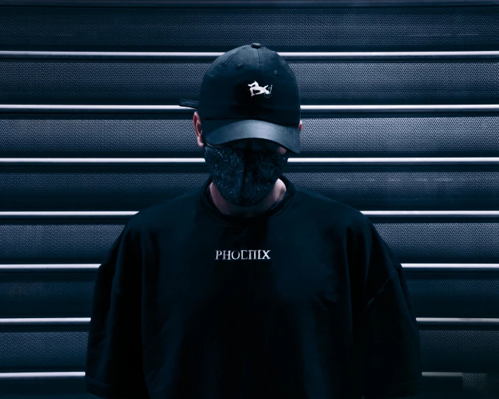 a man wearing a black shirt and a black hat, an album cover, pexels contest winner, techwear clothes, phoenix head, playrix, finely masked