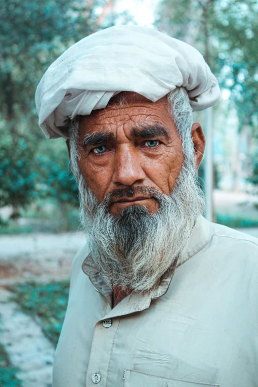 a man with a long beard wearing a hat, inspired by Steve McCurry, pexels contest winner, dau-al-set, an afghan male type, wrinkly forehead, man wearing a closed cowl, slightly tanned