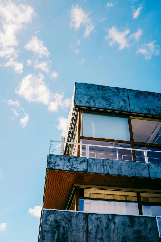 a tall building with a balcony on top of it, inspired by Tadao Ando, unsplash, modernism, summer sky, iron cladding, big sky