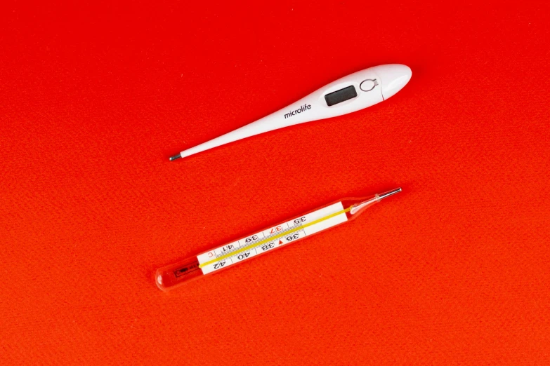 a thermometer and a needle on a red surface, by Julia Pishtar, dau-al-set, incubator medpods, cool white color temperature, flatlay, white