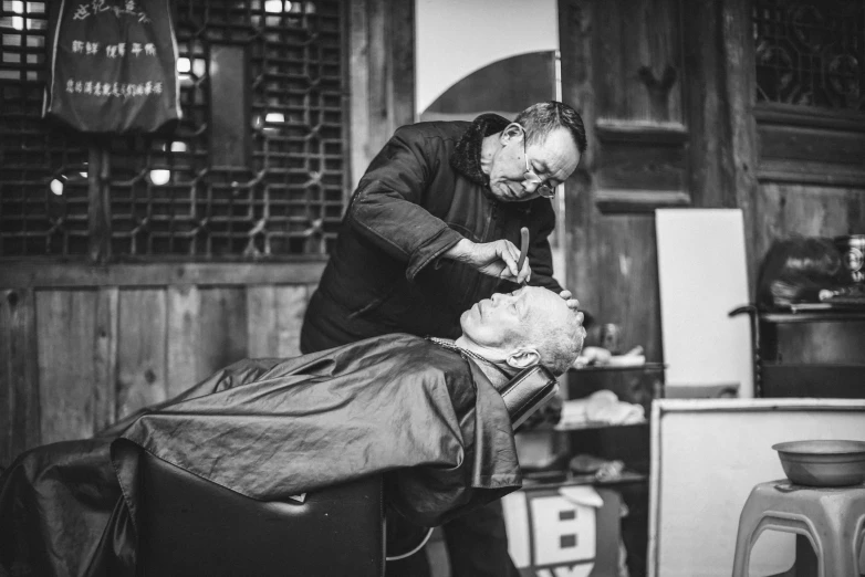 a man getting a haircut at a barber shop, a black and white photo, taoist priest, old man doing hard work, unsplash photo contest winner, 💋 💄 👠 👗