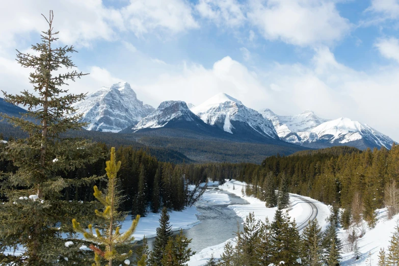 a man riding skis down a snow covered slope, inspired by James Pittendrigh MacGillivray, pexels contest winner, hurufiyya, scenic view of river, banff national park, a cozy, on a canva