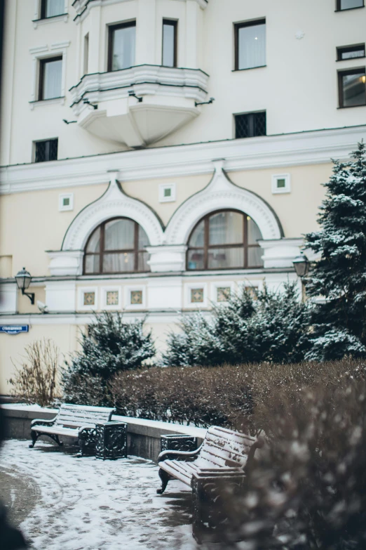 a couple of benches that are in the snow, inspired by Vasily Surikov, trending on unsplash, danube school, exterior view, round windows, low quality photo, in moscow centre