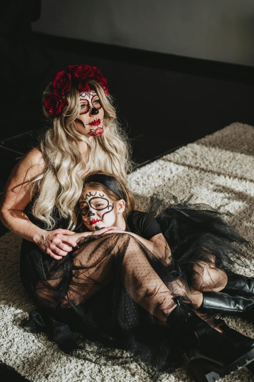 a woman sitting on top of a bed next to a child, pexels contest winner, lowbrow, dia de los muertos makeup, crawling on the ground, profile image, black roses