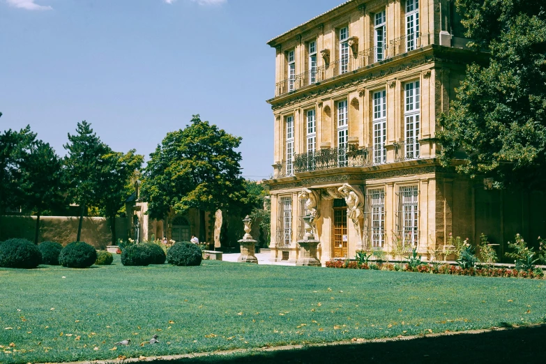 a large building sitting on top of a lush green field, a marble sculpture, inspired by François Girardon, pexels contest winner, rococo, ochre, courtyard, slide show, 2000s photo