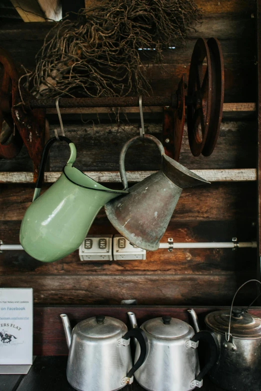 a number of pots and pans on a shelf, by Jan Tengnagel, trending on unsplash, renaissance, in an old west cabin, watering can, hanging lanterns, green and brown color palette