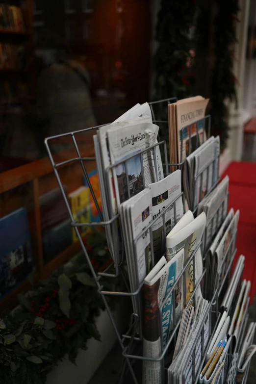 a bunch of newspapers sitting on top of a metal rack, delightful surroundings, magazine sales, holywood scene, holiday season