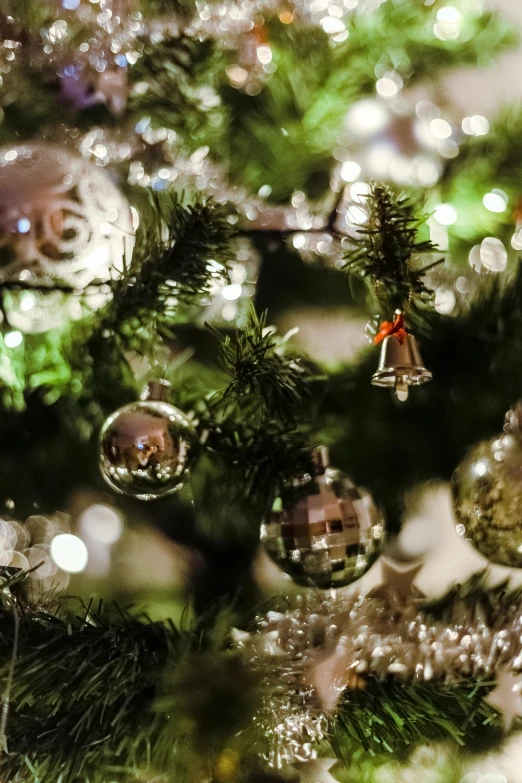 a close up of a christmas tree with ornaments, by Jakob Gauermann, happening, glittering silver ornaments, bells, in the evening, thumbnail