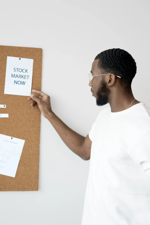 a man standing in front of a bulletin board, trending on unsplash, african canadian, trading stocks, white background, cardboard cutout