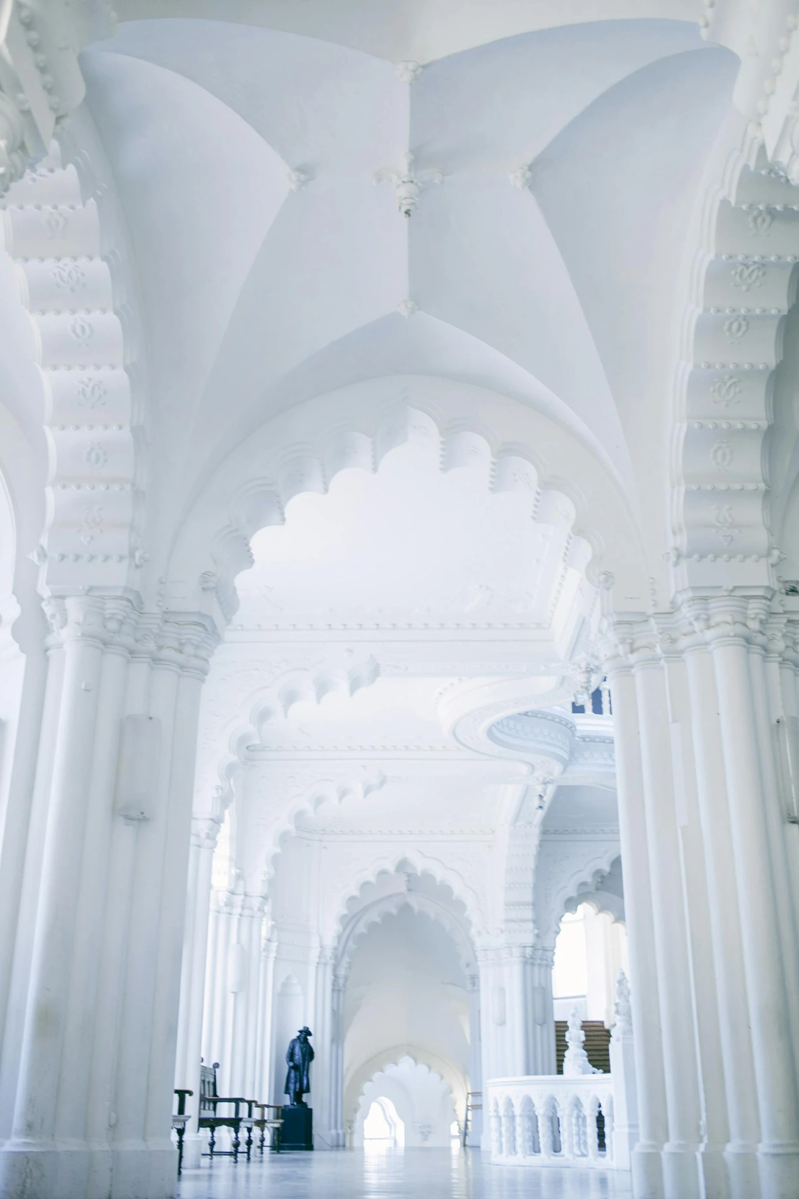 a couple of people that are standing in a building, inspired by Alberto Morrocco, trending on unsplash, arabesque, white sweeping arches, the blessed aisles, white color scheme, minarets