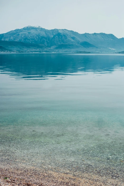 a large body of water with mountains in the background, a picture, minimalism, croatian coastline, f / 2 0, reflects, trending photo