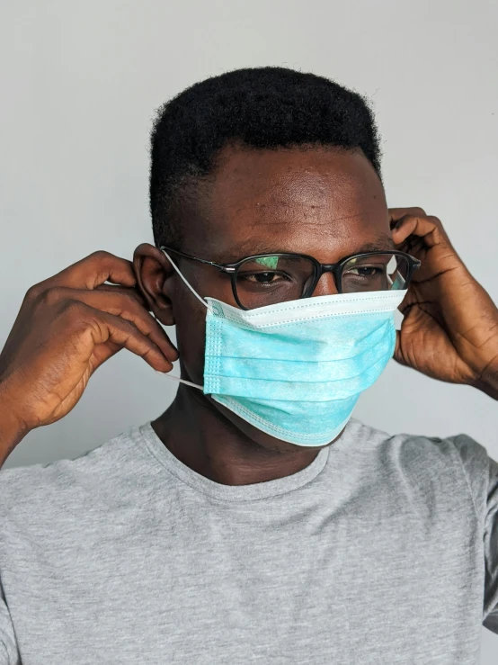a man wearing a face mask and glasses, by Adam Marczyński, trending on pexels, afrofuturism, made of lab tissue, tinnitus, surgical supplies, thumbnail