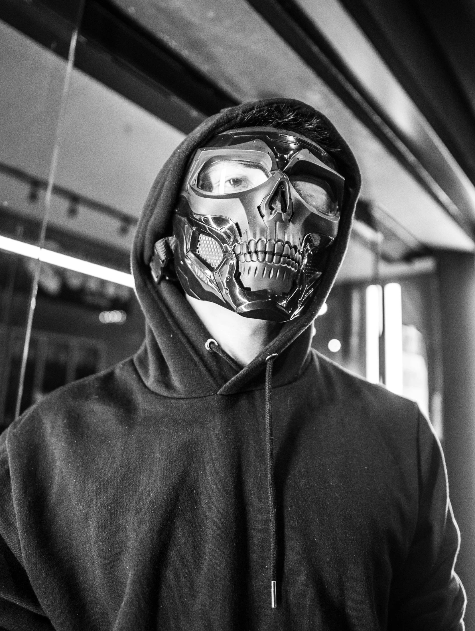 a black and white photo of a man wearing a mask, by Adam Marczyński, spiderman as terminator, techwear clothes, full skull shaped face cover, metal jaw