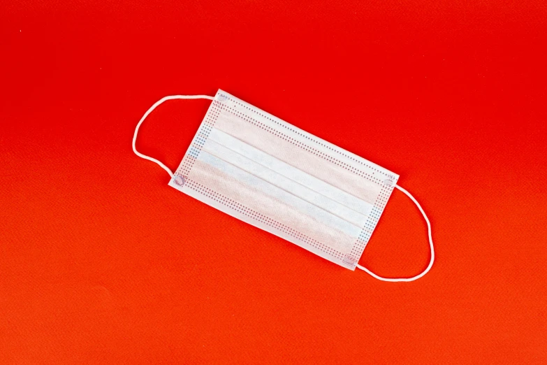 a white face mask on a red background, pexels, plasticien, surgical supplies, striped, on a pale background, white and orange