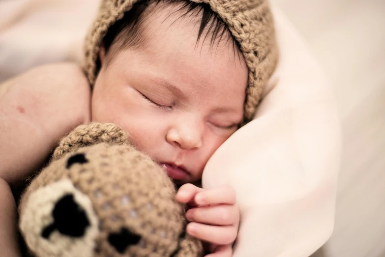 a baby is sleeping with a teddy bear, pexels contest winner, symbolism, portrait close up, brown, lachlan bailey, side portrait imagery