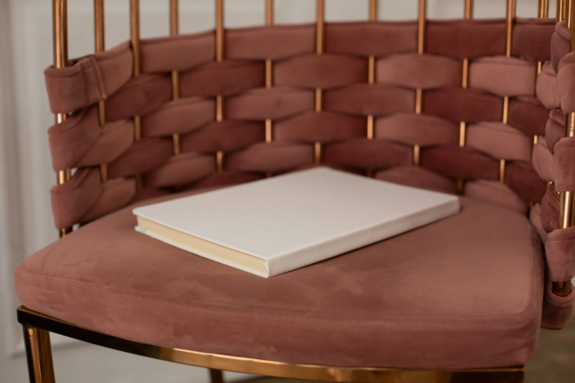 a book sitting on top of a pink chair, ivory and copper, solid colours material, medium - shot, lots de details