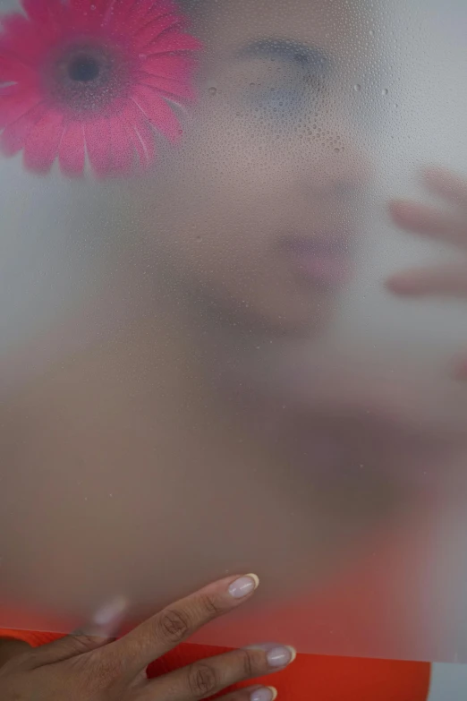 a woman with a pink flower in her hair, an album cover, inspired by Bert Stern, pexels contest winner, feathers ) wet, ((mist)), looking into a mirror, movie scene close up