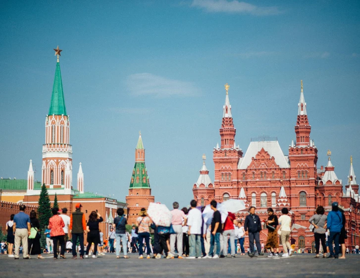 a group of people standing in front of a building, pexels contest winner, socialist realism, kremlin, seen in the distance, square, reddish