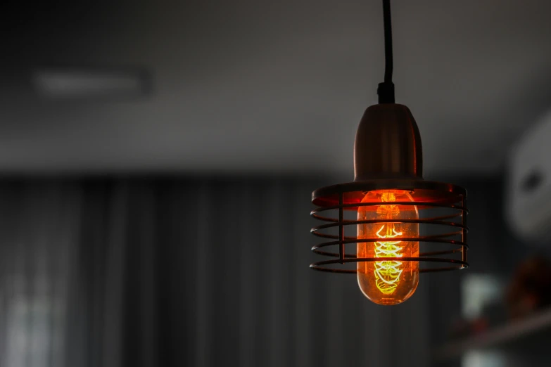 a close up of a light hanging from a ceiling, inspired by Elsa Bleda, unsplash, orange lamp, edison bulb, copper details, retro stylised