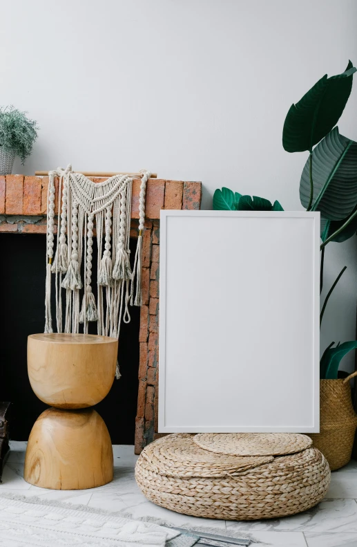 a picture frame sitting on top of a table next to a fireplace, a poster, unsplash contest winner, in a white boho style studio, macrame, high quality photo, blank background