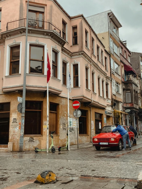 a red fire hydrant sitting on the side of a street, a photo, by Cafer Bater, pexels contest winner, art nouveau, istanbul, cars parked underneath, today\'s featured photograph 4k, house's and shops and buildings