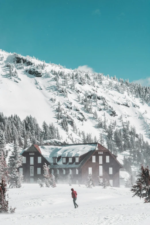 a man riding skis down a snow covered slope, peaceful wooden mansion, large rocky mountain, top selection on unsplash, mint