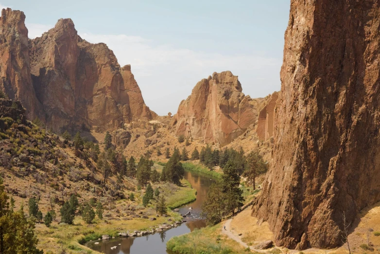 a river running through a lush green valley, a photo, by Pamela Ascherson, pexels contest winner, plein air, tall stone spires, black mesa, red narrow lava rivers, brown