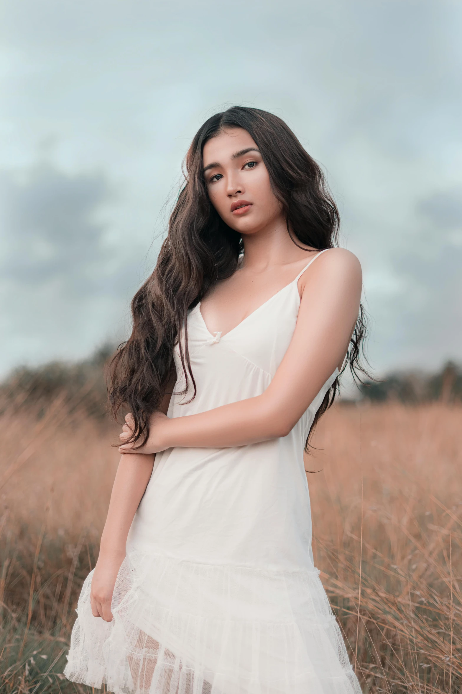 a woman in a white dress standing in a field, by Robbie Trevino, trending on pexels, asian girl with long hair, promo image, wearing a camisole, high quality image