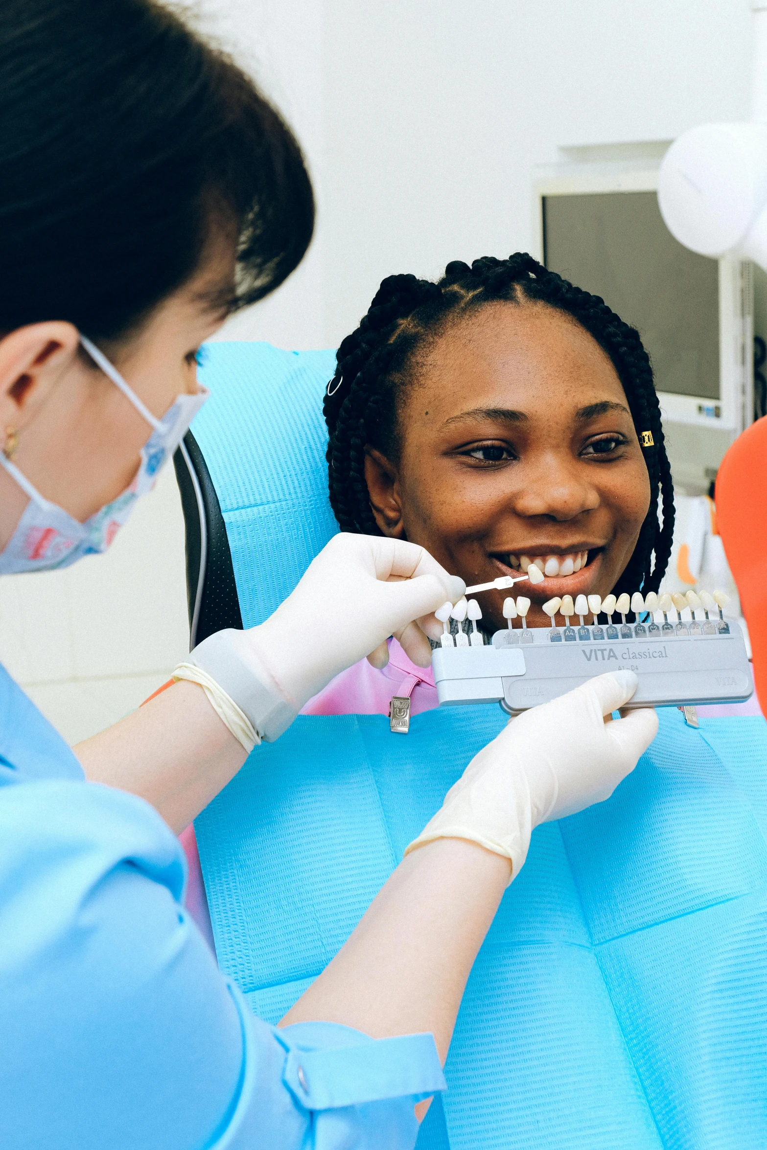 a woman getting her teeth examined by a dentist, a colorized photo, pexels contest winner, photo of a black woman, wearing a light grey crown, cool and bright tint, girls