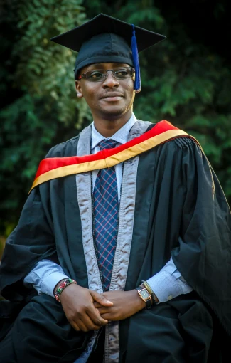 a man in a graduation gown posing for a picture, a picture, by Chinwe Chukwuogo-Roy, digital image, ash thorp khyzyl saleem, portrait image