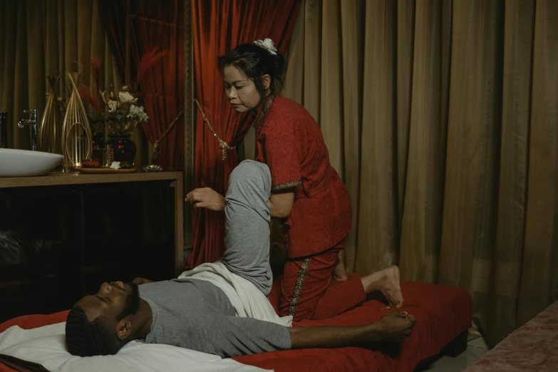 a man laying on a bed next to a woman, pexels contest winner, massurrealism, red shirt brown pants, asian origin, ( ( theatrical ) ), spa