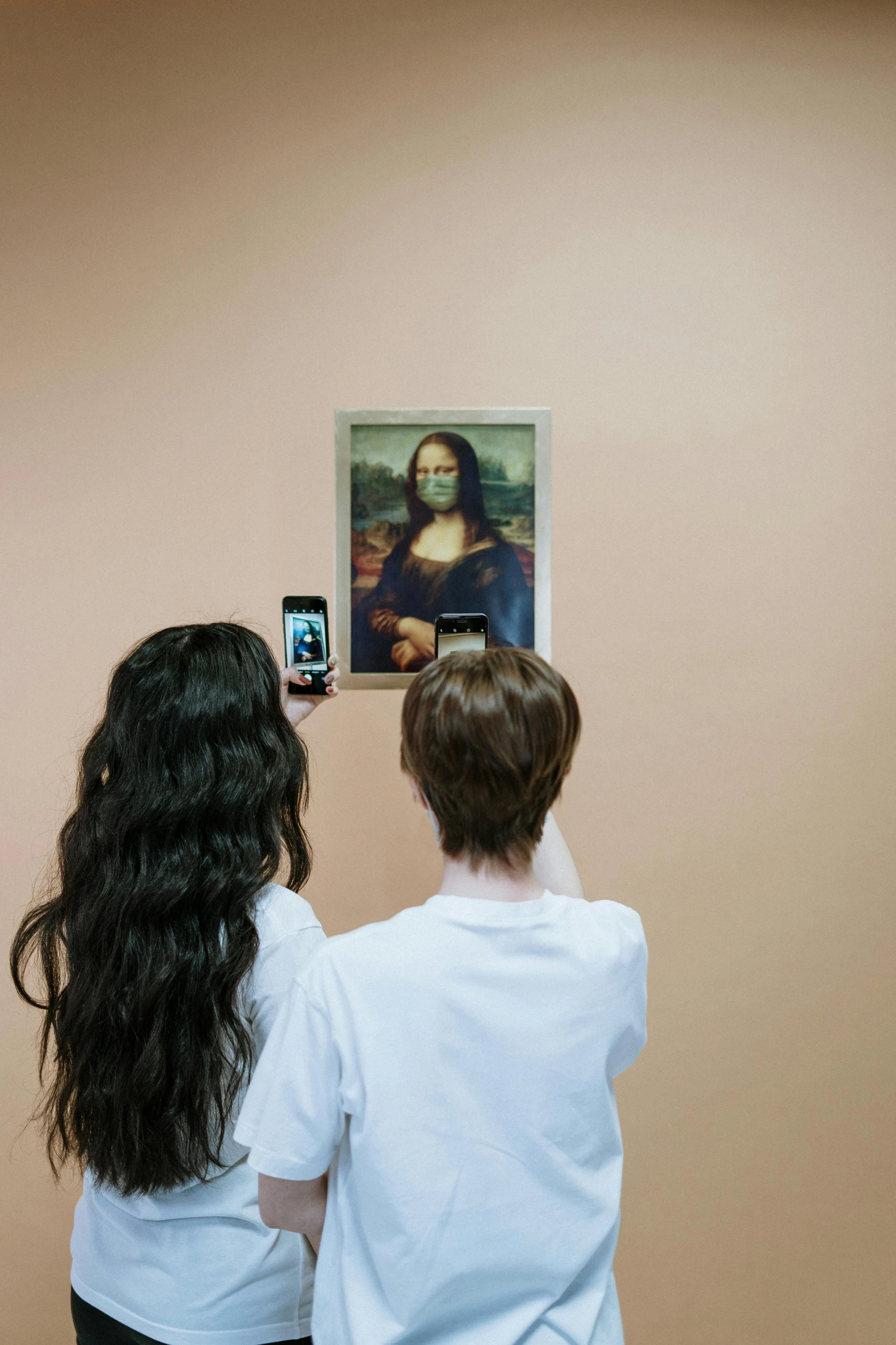 a couple of people standing in front of a painting, a picture, trending on unsplash, interactive art, mona lisa taking a selfie, a boy, facing away from the camera, frightening appearance