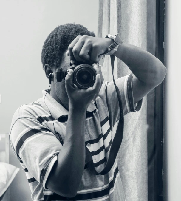 a man taking a picture of himself in the mirror, a black and white photo, by Chinwe Chukwuogo-Roy, pexels contest winner, art photography, he is about 20 years old | short, holding a camera, nostalgic 8k, emmanuel shiru