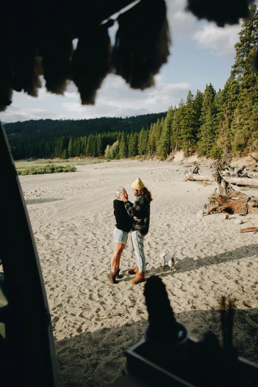 a couple of people standing on top of a sandy beach, near a river, cozy, british columbia, inside an epic