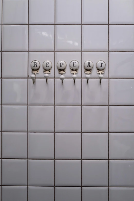 a row of faucets mounted to the side of a tiled wall, an album cover, inspired by Jan Kupecký, unsplash, control panel, yeast, repetition, grey