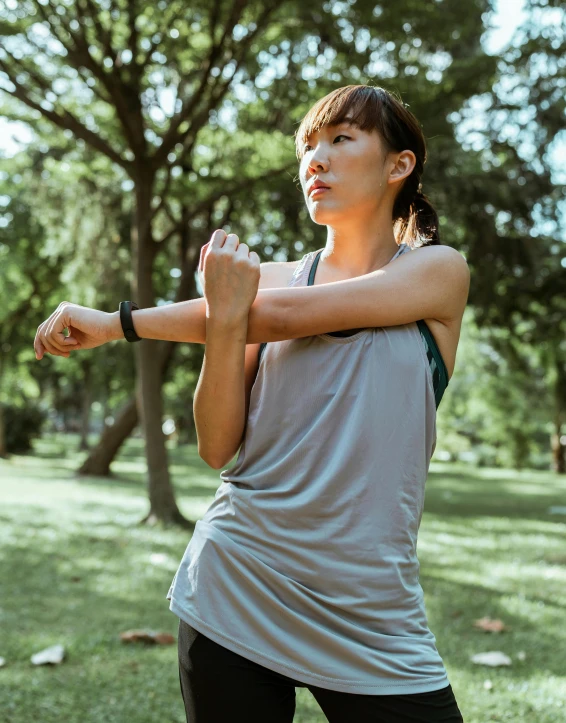 a woman standing on top of a lush green field, wearing two silver bracelets, wearing fitness gear, singapore, profile image