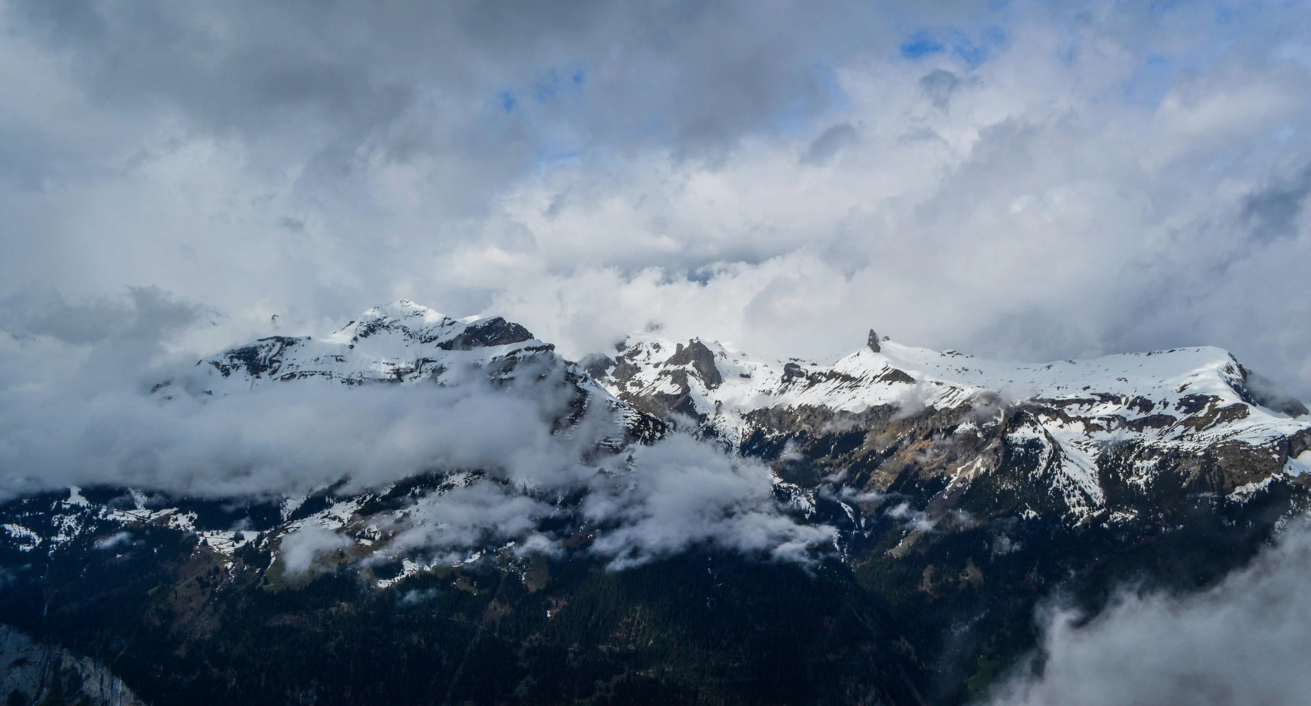 a group of people standing on top of a snow covered mountain, by Daniel Seghers, pexels contest winner, les nabis, low clouds after rain, panoramic, fan favorite, viewed from bird's-eye