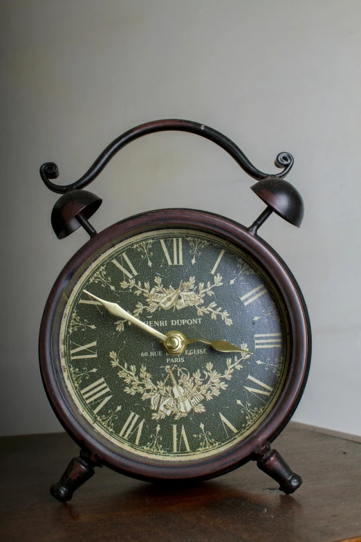 a clock sitting on top of a wooden table, brown, thumbnail, floral, detailed product shot