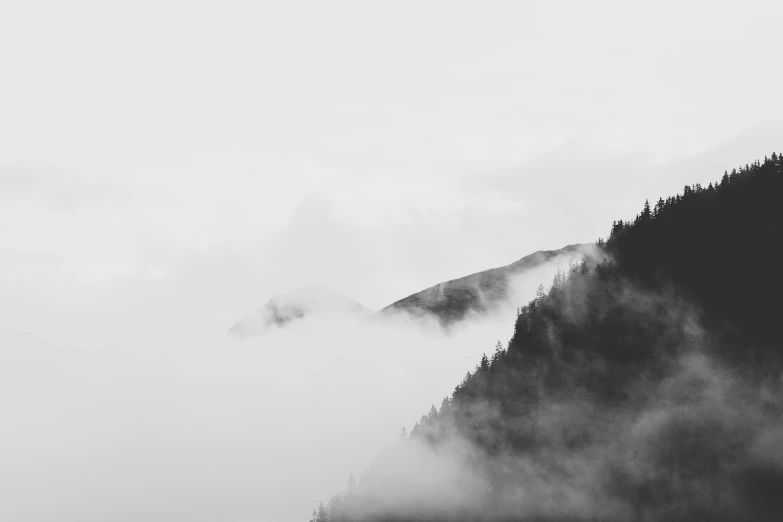 a black and white photo of a foggy mountain, by Karl Buesgen, pexels contest winner, minimalism, ominous! landscape of north bend, 4k vertical wallpaper, white clouds, hill with trees