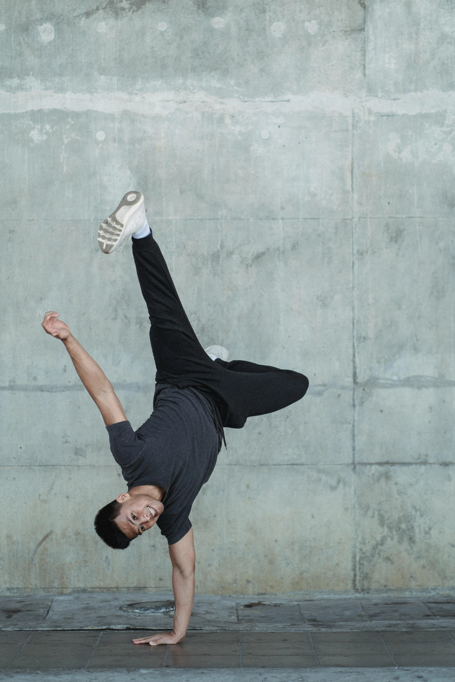 a man doing a handstand in front of a concrete wall, inspired by Fei Danxu, males and females breakdancing, headshot, bo chen, julian ope