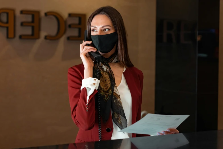 a woman wearing a mask while talking on a cell phone, luxurious environment, staff, red scarf, jakub rebelka