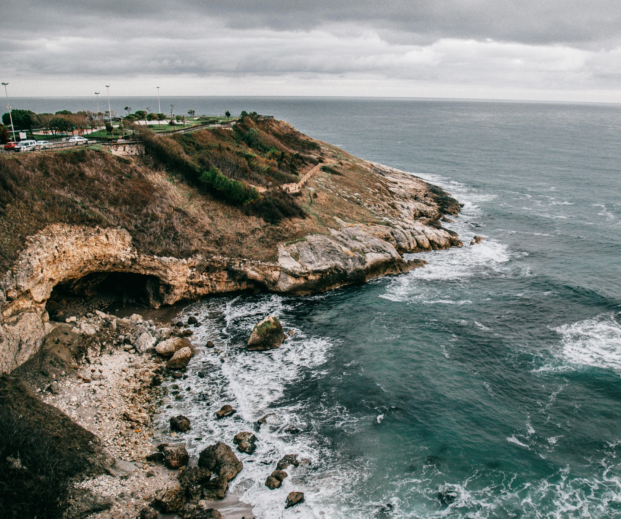 a large body of water next to a cliff, pexels contest winner, overcast skies, piroca, birdseye view, beachfront mansion