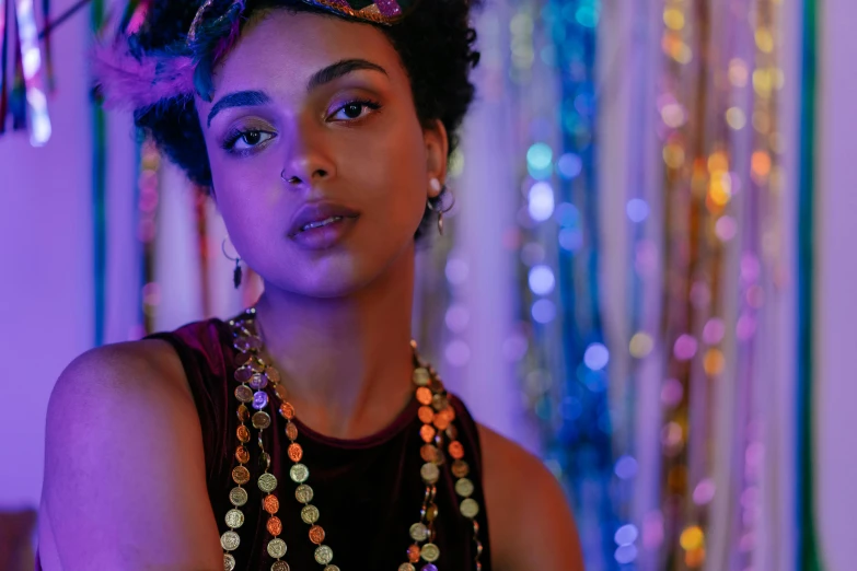 a close up of a person wearing a necklace, afrofuturism, party lights, a still of an ethereal, shot on sony a 7, draped in silky purple and gold