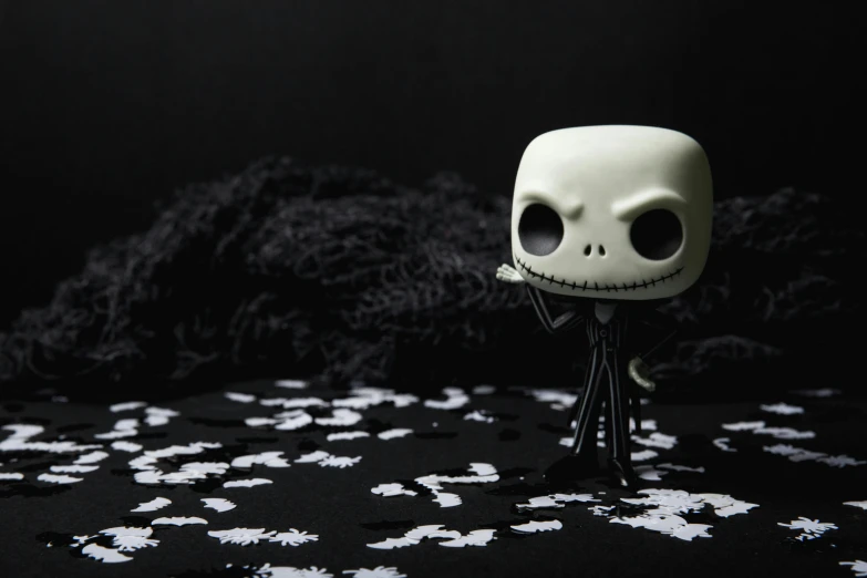 a close up of a figurine of a skeleton, an album cover, inspired by Jack Boul, pexels contest winner, as a full body funko pop!, chilly dark mood, a dark, (night)