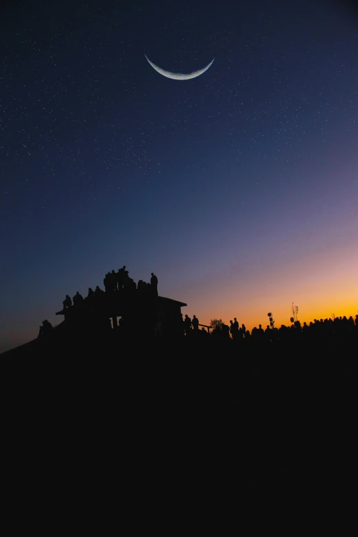 a group of people standing on top of a hill under a crescent, by Sebastian Spreng, unsplash contest winner, sunset panorama, hut, distant twinkling stars, crowded silhouettes