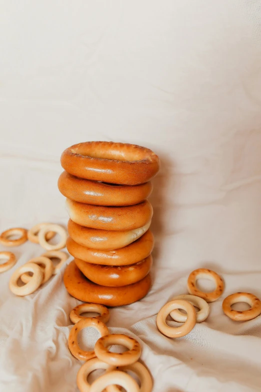 a stack of donuts sitting on top of a table, product image, bruegels the tower of babel, natural soft rim light, various sizes