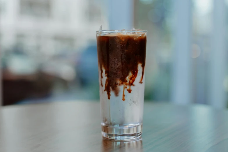 a drink sitting on top of a wooden table, smothered in melted chocolate, froz, profile image, thumbnail